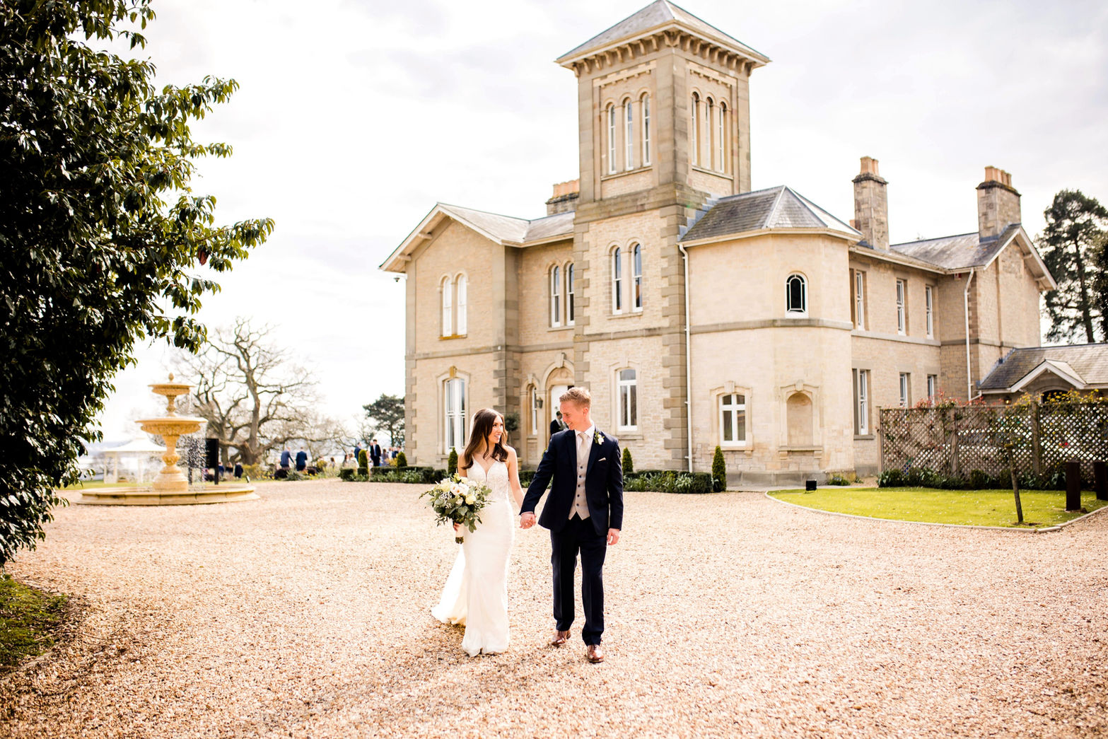 bride and groom walking towards their wedding photographer at St Tewdrics House on their wedding day