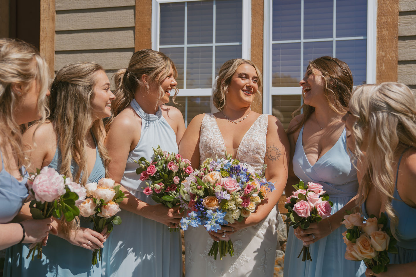 Caberfae wedding with colorful pastels, bridesmaid and bride standing in front of the lodge.