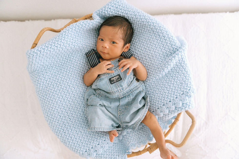Jiovanni rests in a newborn prop at Little White Photo Studio in Frederick, Colorado