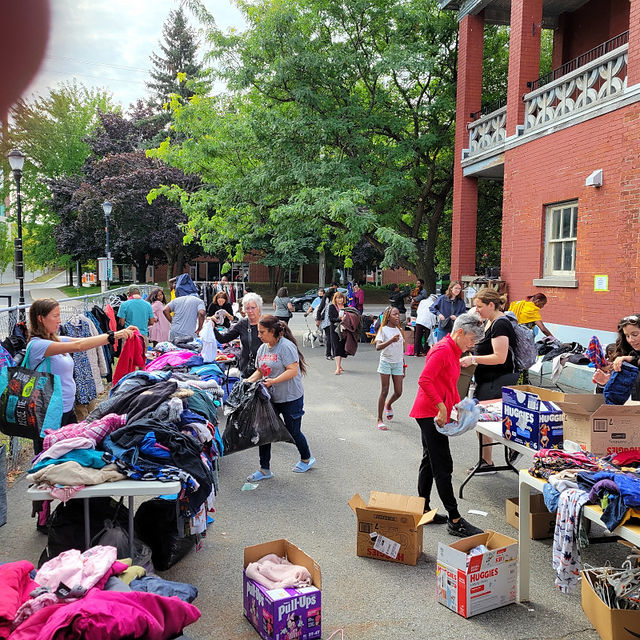 Visitors to the giveaway look through a large collection of the clothes and other items