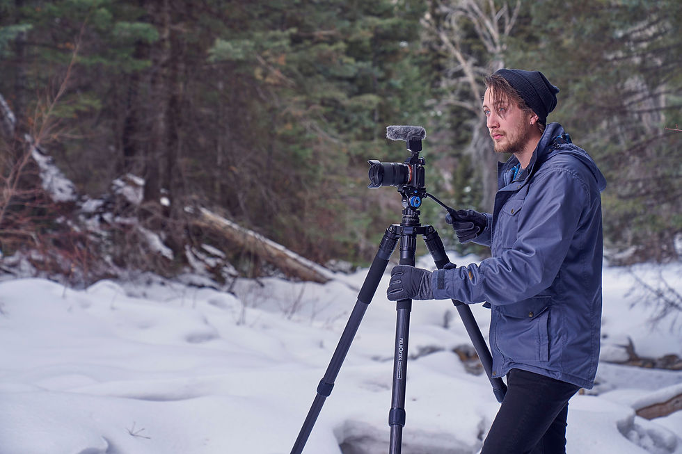 Lifestyle product image that was taken outside in the snow of a man holding a tripod.