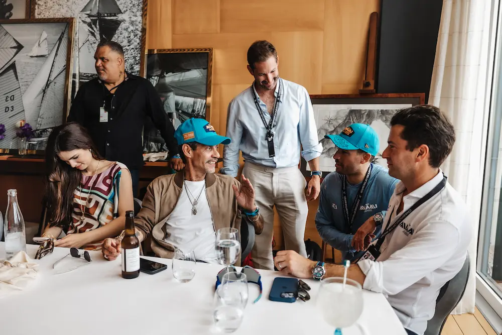 Marc Anthony in Team Miami apparel talks with fellow guests at the dockside lounge during race weekend
