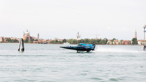 E1 Team Miami RaceBird hydrofoil gliding above the Venetian waters at high speed, city skyline visible in the background.