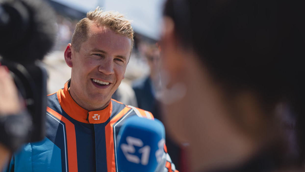 Erik Stark smiling in a candid moment, wearing sunglasses and facing a friend.