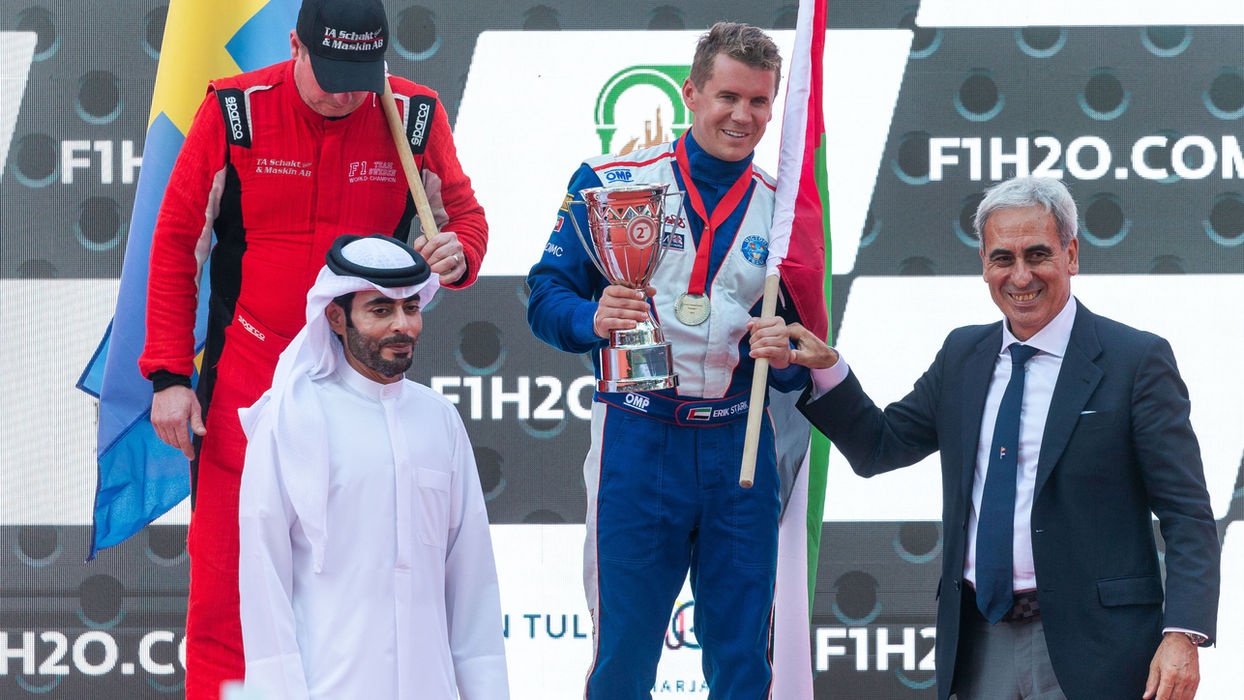 Erik Stark raising a trophy on the F1H2O podium with fellow competitors and event organizers.