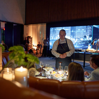 Chef hosting an intimate private dining experience as part of a curated hospitality event.