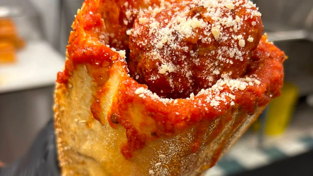 Meatball sandwich with tomato sauce and grated cheese