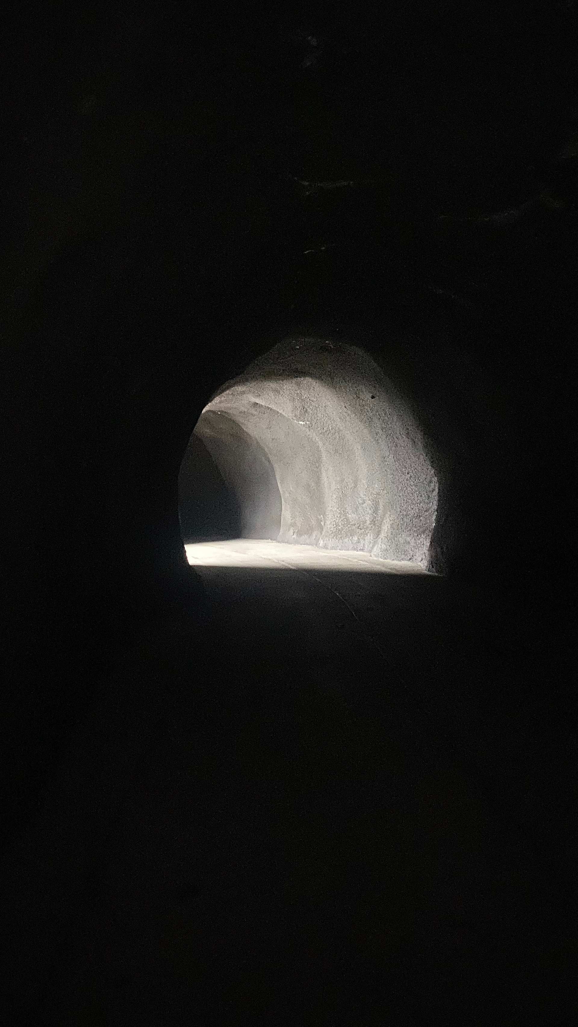 Photograph of a dark, shadowy tunnel illuminated with several shafts of light.
