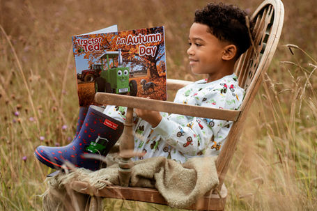 Boy sitting in chair, reading a book