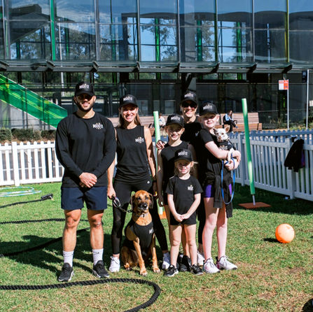 family wearing black sports wear, holding dogs