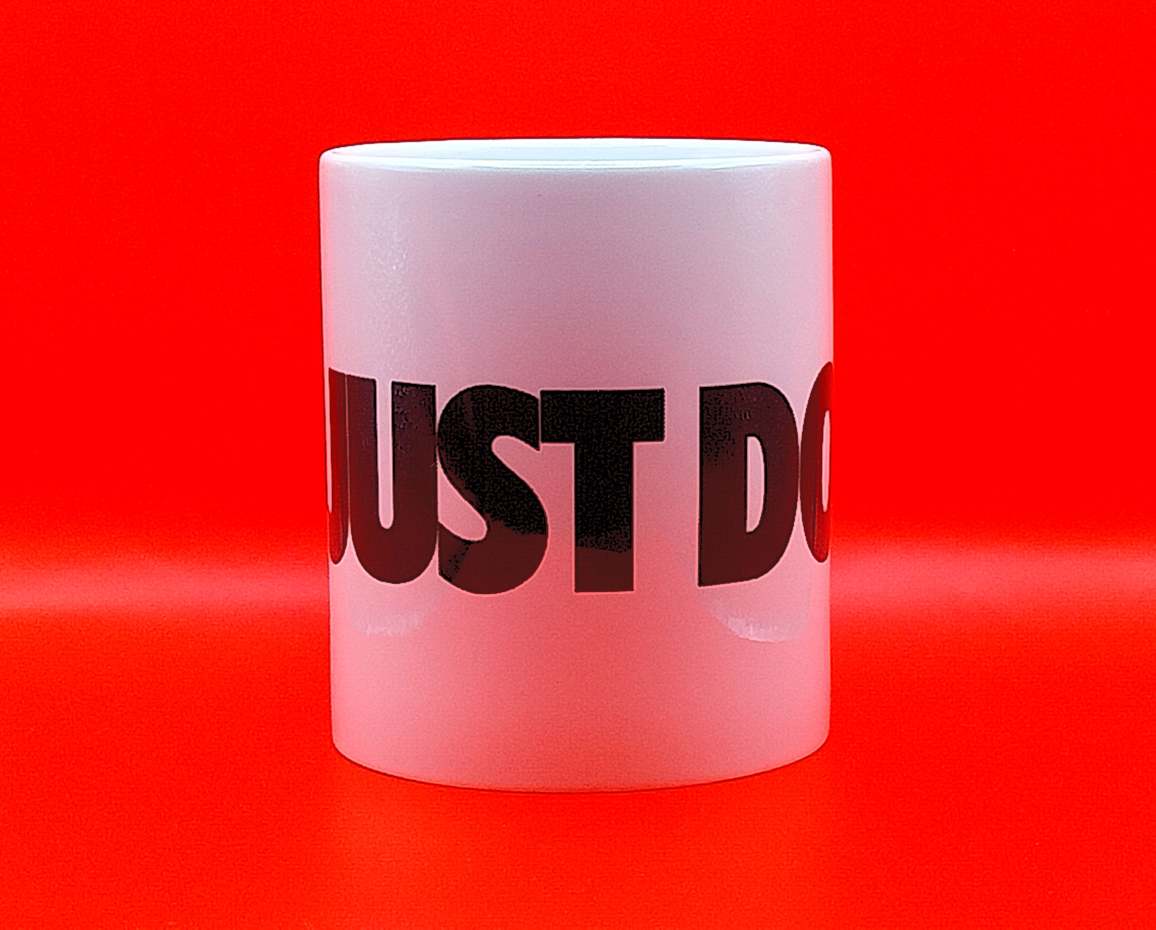Mug blanc avec le texte "JUST DO IT" sur fond rouge vif.