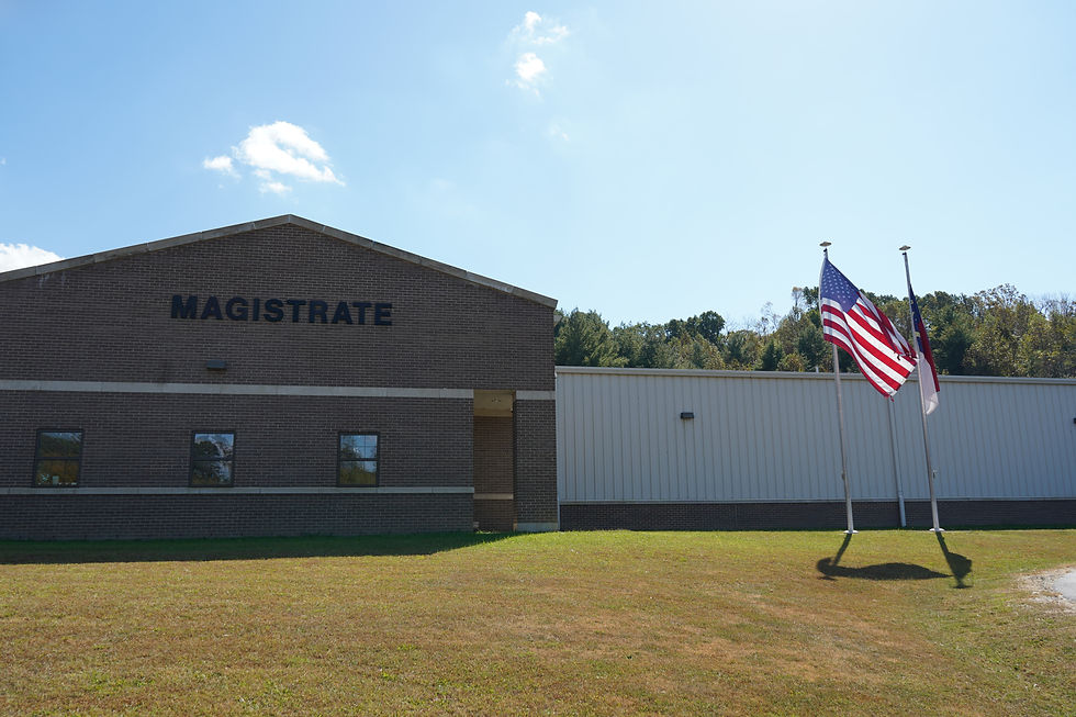 Magistrate building with brick facade and U.S. flag outside under a bright blue sky, calm daytime scene