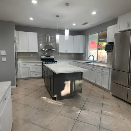 Spacious custom kitchen remodel featuring white cabinetry and a contrasting dark center island by Four A's Remodeling in San Diego.