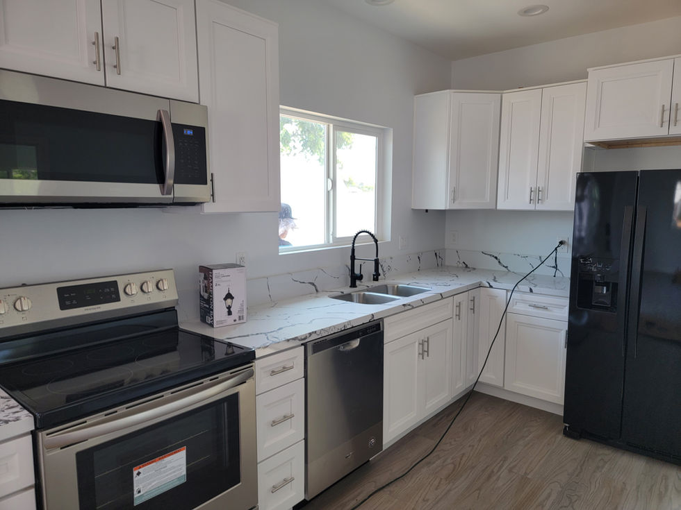 a kitchen with white cabinets and stainless steel appliances and a box that says ' lg ' on it