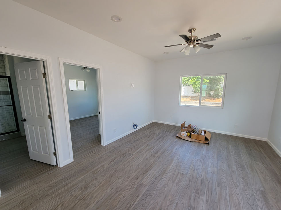 an empty room with a ceiling fan and a box on the floor