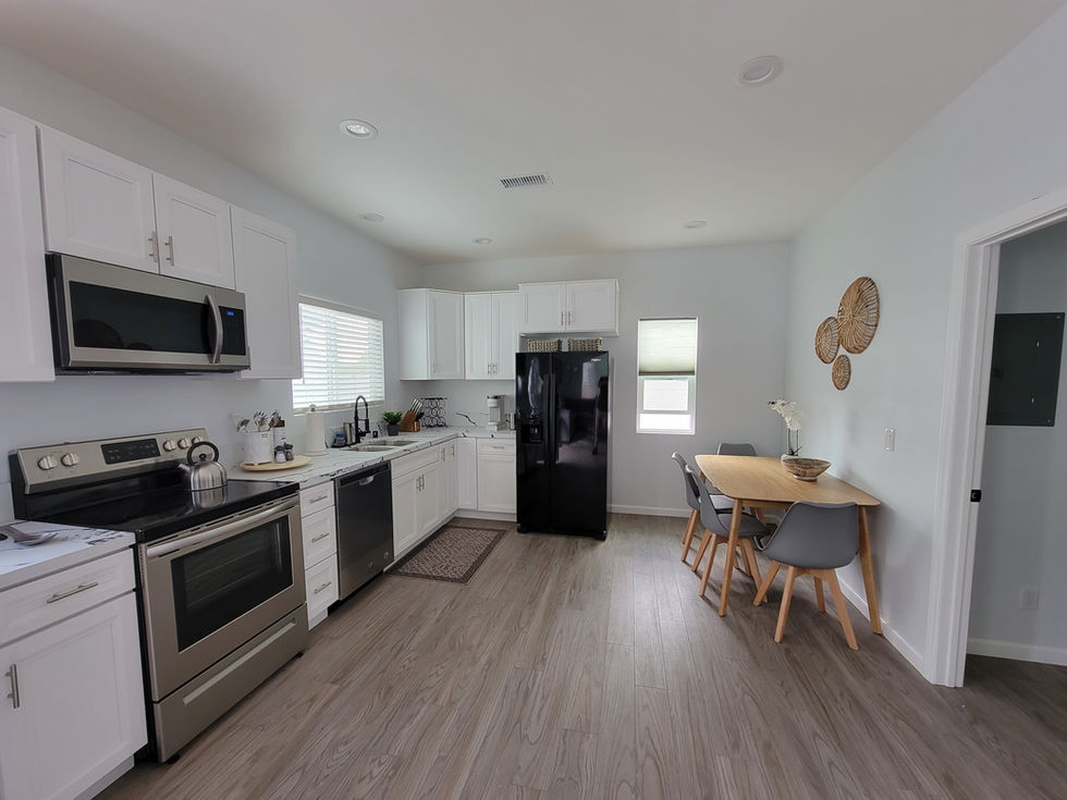 a kitchen with white cabinets and a black refrigerator
