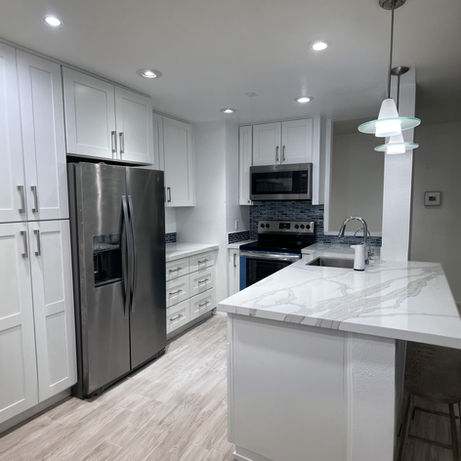 Bright kitchen upgrade showcasing white shaker cabinets and a custom quartz peninsula built by Four A's Remodeling.