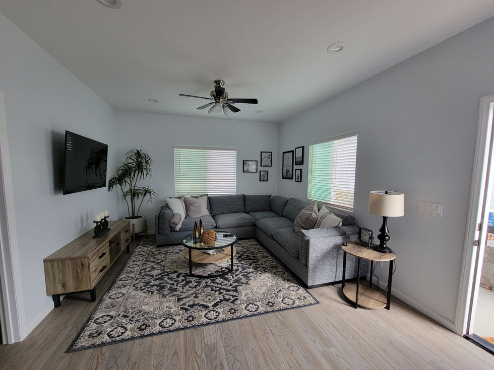 a living room with a sectional couch and a ceiling fan