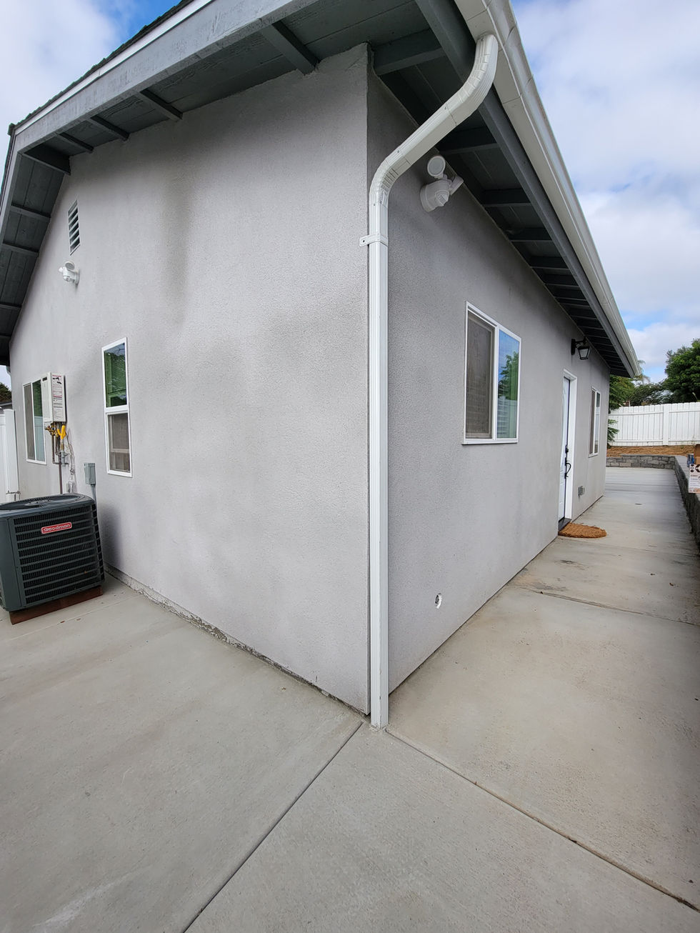 a gray house with a gray air conditioner on the side