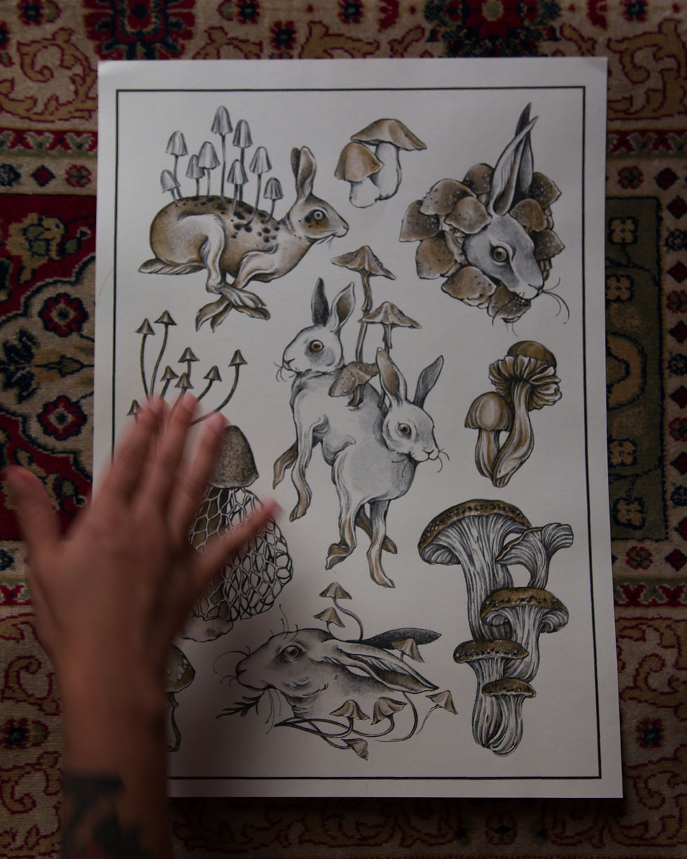 Impresso com desenhos de coelhos e seres místicos híbridos e cogumelos nas cores preta e dourada