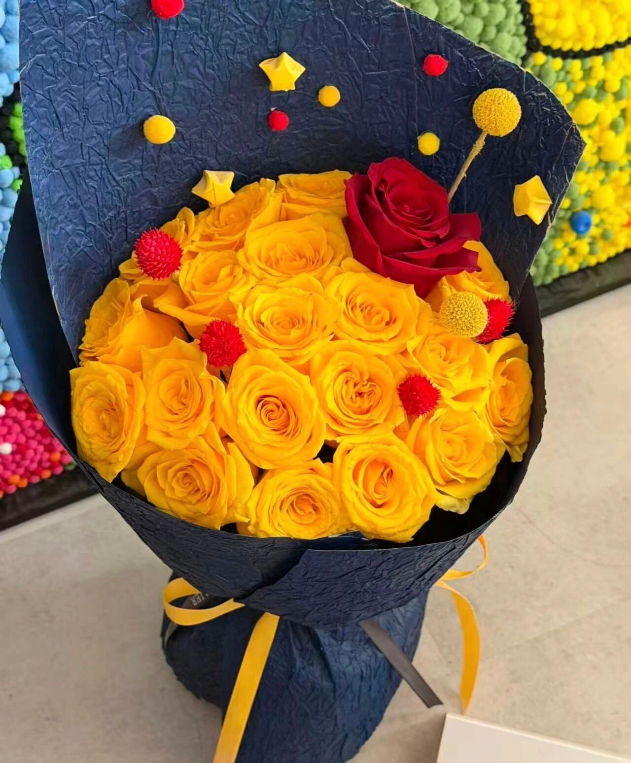 Navy‑Wrapped Yellow Rose Bouquet with Star & Pom‑Pom Accents