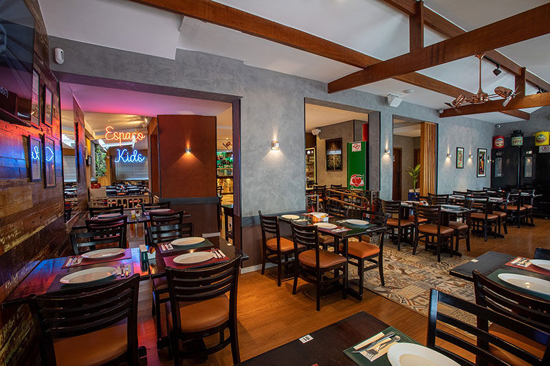 Interior view of a restaurant with tables and chairs, Espaço Kids caetanos.