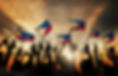 Group of People Waving Filipino Flags in Back Lit.jpg