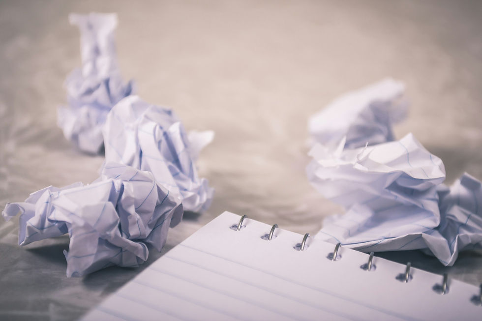 Crumpled paper beside a blank notebook, representing frustration and a fresh start with anger management counselling