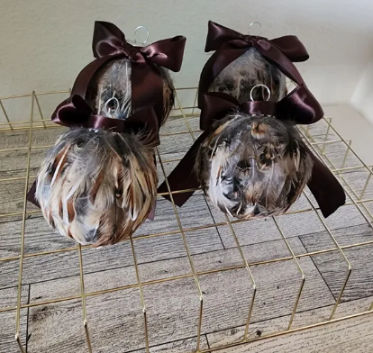 Quail feather wrapped glass orb for ornament with ribbon.