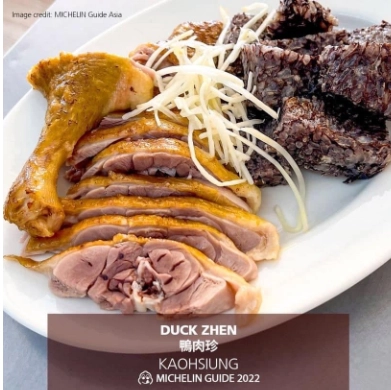 盤中擺放著切片鴨肉和黑色米血，配以白色薑絲裝飾