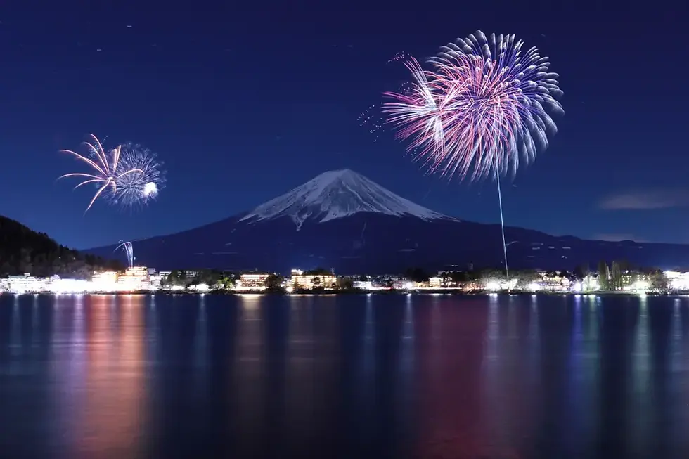 河口湖冬花火,夜空中煙火綻放,遠處富士山靜謐矗立,湖面倒映城市燈光,營造出寧靜浪漫的節慶氛圍。