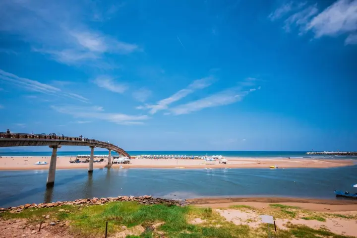 福隆海水浴場全景：跨越雙溪河的彩虹橋與湛藍大海交織的畫面