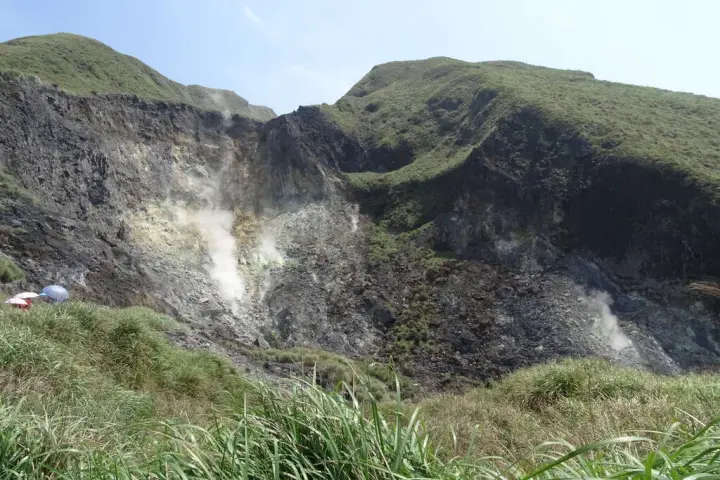 陽明山小油坑，山景與綠色草地交織