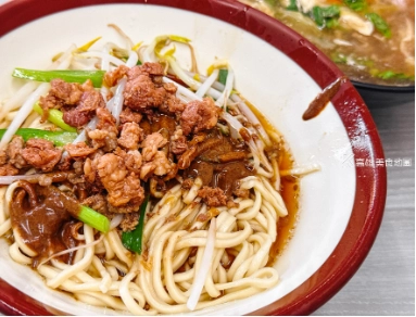 左營阿婆面，紅邊碗中盛有肉臊麵，麵條配有肉末、豆芽和蔥，旁邊是另一碗湯