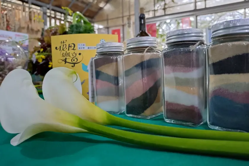 桌上擺著海芋花以及4瓶彩色罐裝的沐浴鹽