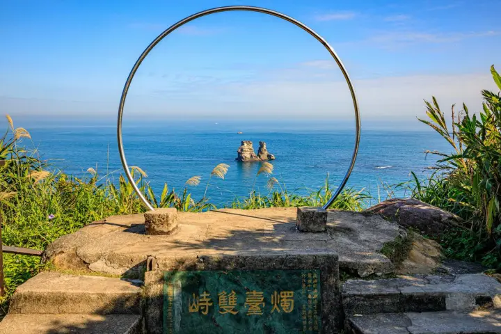 金山獅頭山公園步道景點，燭台雙嶼地標以半圓形佇立在石階上，遠眺可以看到湛藍海景