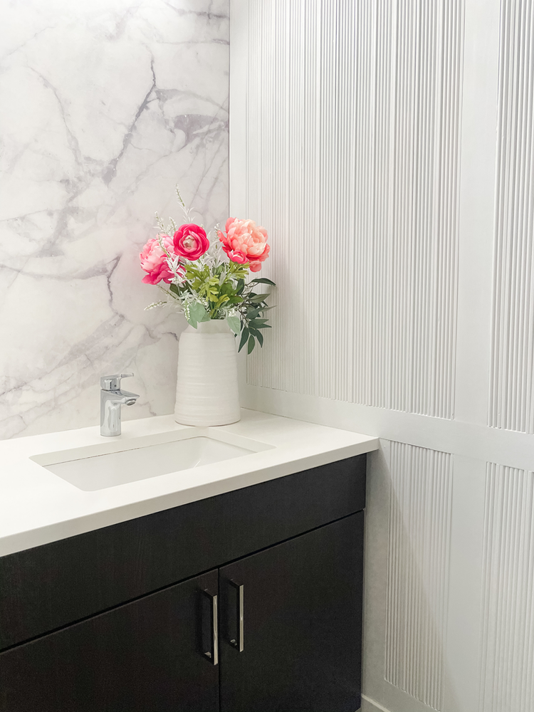 Modern Powder Room Reveal with a fluted accent wall, marble wallpaper and gray paint to create the perfect bathroom oasis. A stunning DIY powder room makeover with beautiful millwork. 