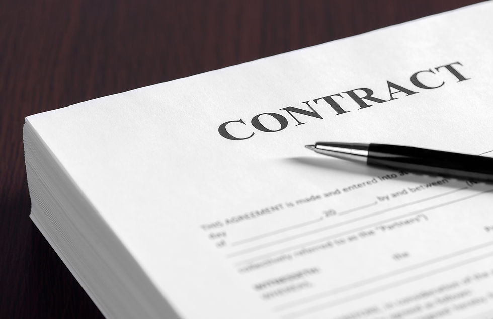Close-up of a contract document with a black pen on a dark desk, emphasizing formal paperwork and agreement.