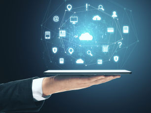 Hand holding a tablet with glowing cloud, app, search, and security icons in a blue digital network background