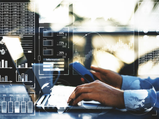 Hands typing on a laptop overlaid with glowing analytics charts, graphs, percentages, and globe icons in a bright office.
