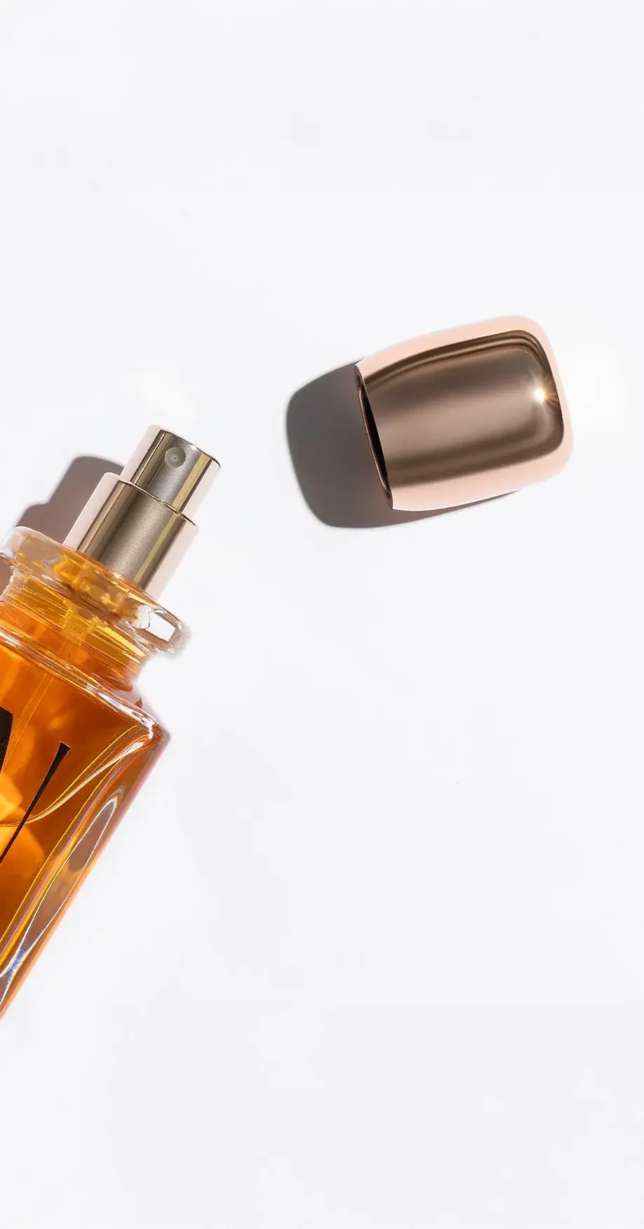 Ultra Niche Malta En Or perfume bottle - luxurious amber glass with exposed atomizer and metallic rose gold cap, designed by Identiscents, high-end fragrance packaging supplier in the Middle East.