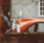 a small orange delivery car outside a window