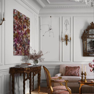 Elegant traditional interior with intricate wall moldings, antique furniture, and a contemporary art piece.
