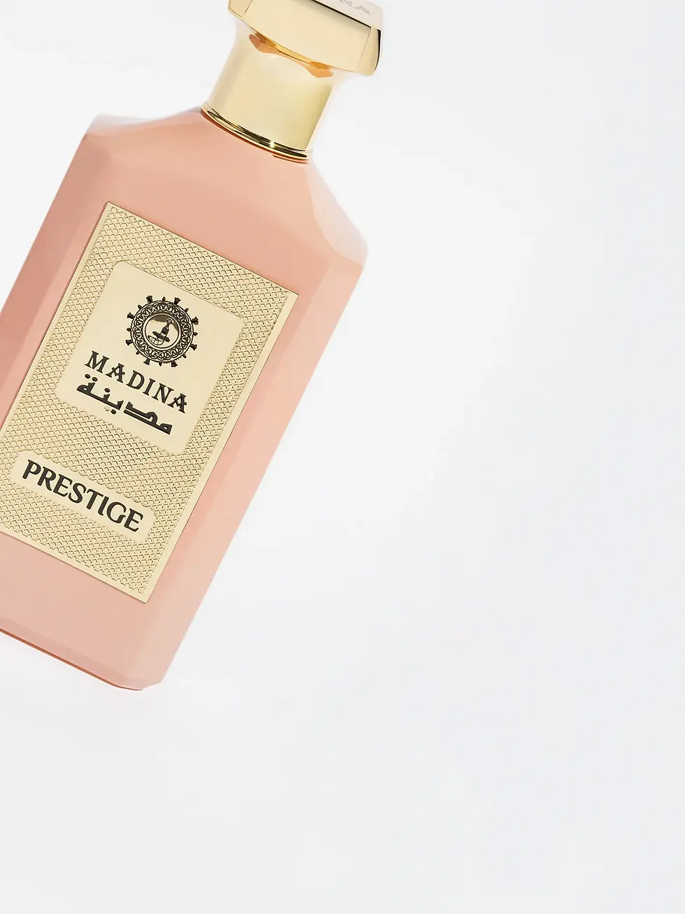 Madina Prestige luxury perfume bottle in a refined blush pink tone, highlighted with an opulent gold label and an elegantly crafted cap, representing timeless elegance in premium fragrance packaging.