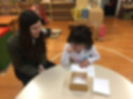 Preschool age child using Montessori mat