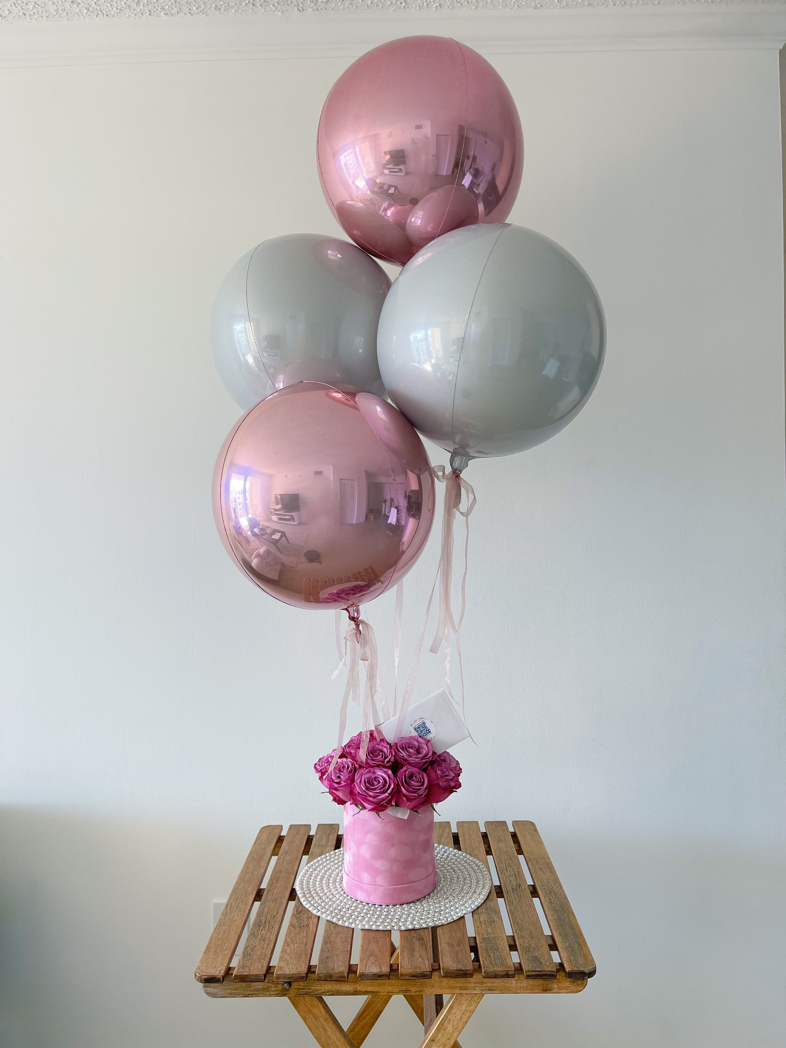 Box of pink roses and balloons on the top