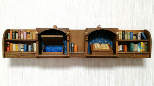 夜籠りを抜けて
図書館の本棚と2つの書見台を短冊のサイズにおさめたミニチュア作品。
天文に関する蔵書が多い本棚です。一方の書見台には分厚い洋書が開かれています。もう一方の書見台の中を覗くと中には星空が広がっています。