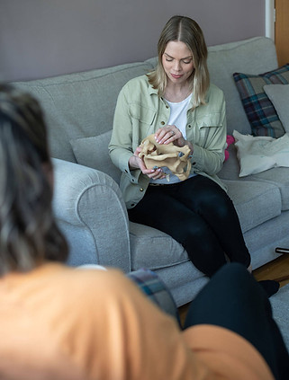 Charlotte from Positive Birth Leeds Sits on a sofa holding a model pelvis
