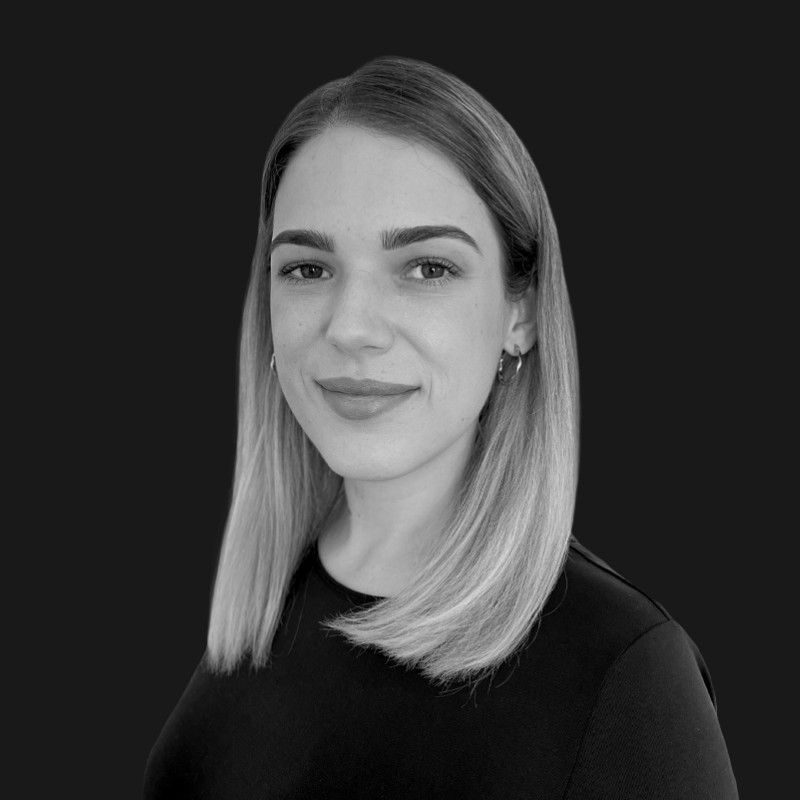 Black and white headshot photograph of Andrea Saravolac with a black background