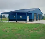 Blue metal building with carport and garage bays